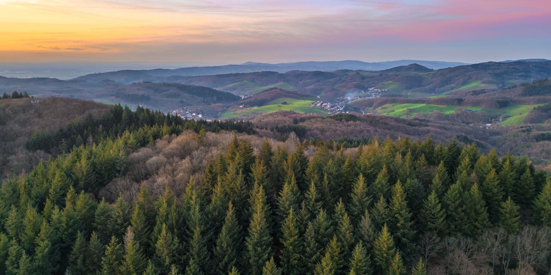 Blick über die bewaldeten Hügel des Odenwalds bei Sonnenuntergang