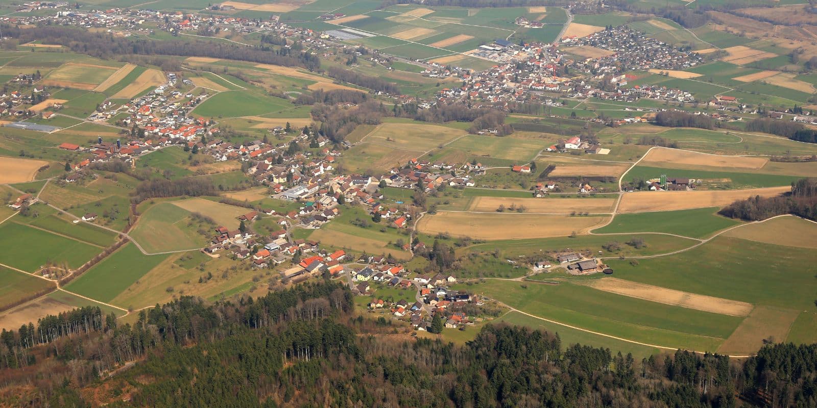 Weite Odenwaldlandschaft mit Wald, Tälern und Fachwerkort